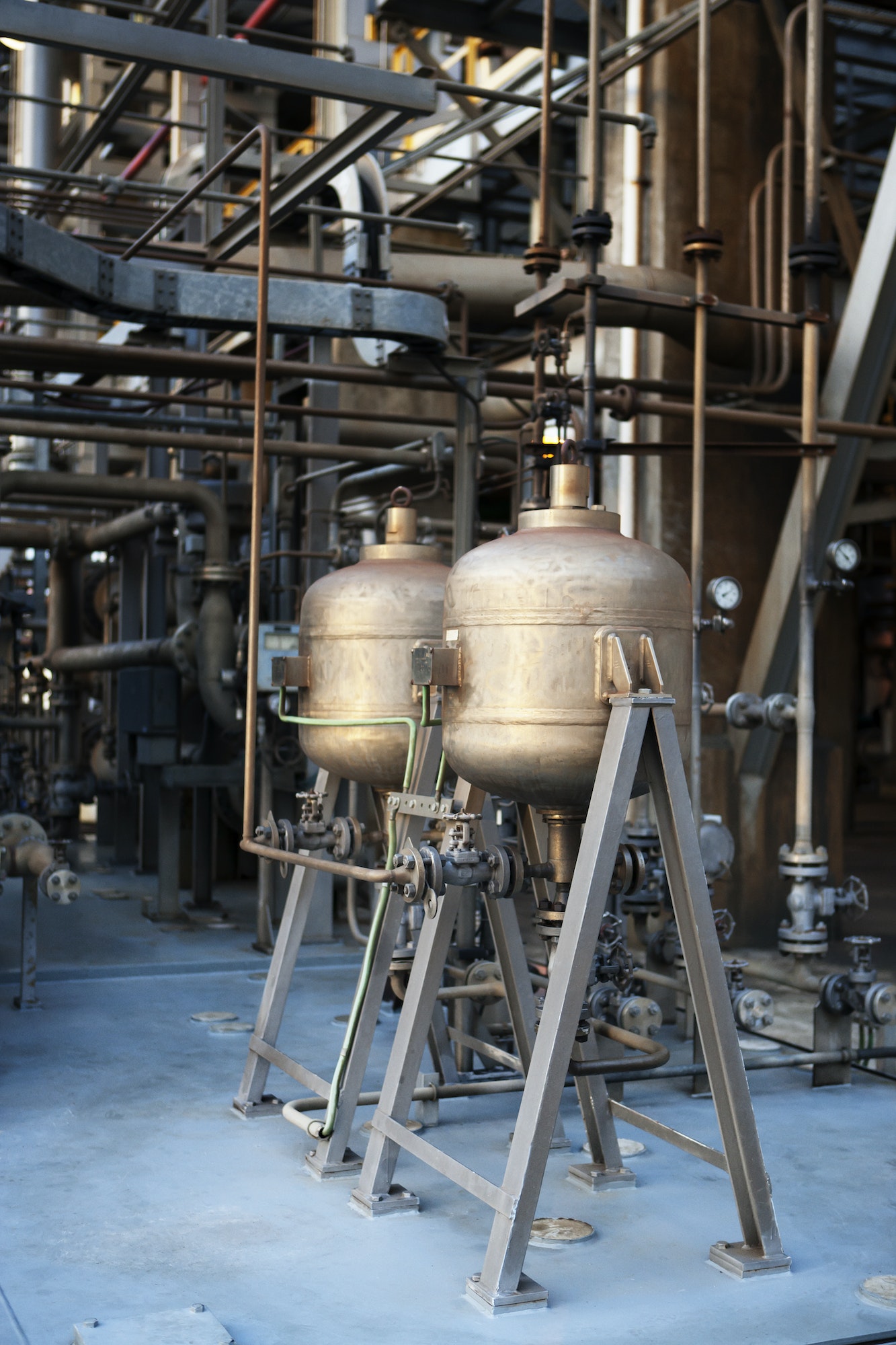 Chemical processing equipment in a thermal power facility, featuring two metallic pressure vessels and extensive piping systems, relevant to fuel delivery services and industrial operations.