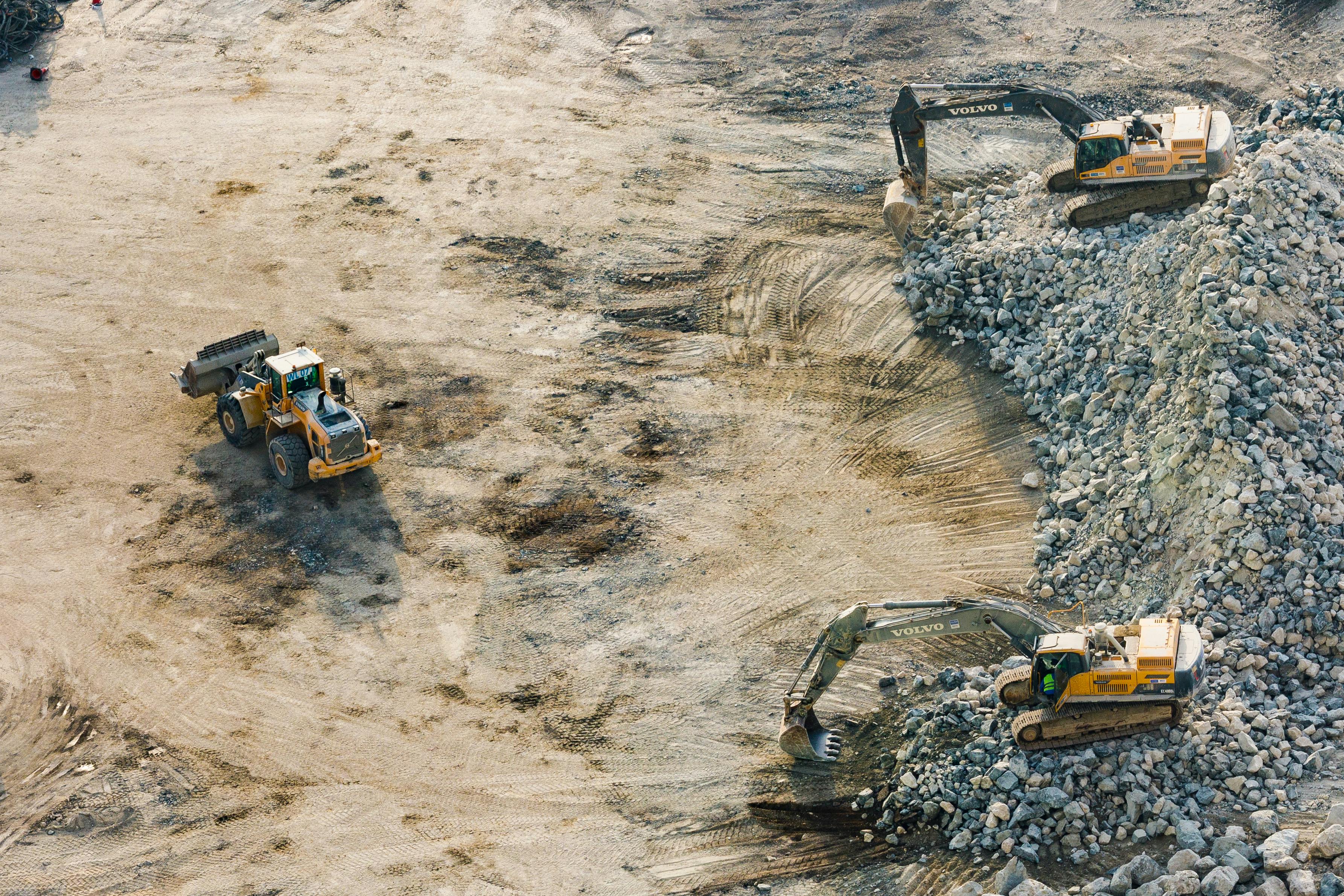 Heavy Equipment at Construction Site – On-Site Fueling Solutions | BettyJet Aerial view of excavators and loaders moving rock and gravel on a large construction site, representing heavy equipment operations powered by BettyJet’s on-site diesel delivery services.